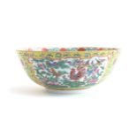 A Chinese famille rose yellow ground porcelain bowl, interlocking florals decorated with panels of