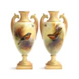 A pair of Royal Worcester bottle vases, hand painted by E. Barker with a chaffinch and robin,