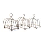 Three silver toast racks: the largest, four division, by Mappin & Webb, London 1919; the other two