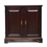 An 18th century oak dwarf press cupboard, the moulded top over two panelled doors, opening to two