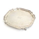 A square silver salver with shaped edge, by S Blanckensee & Son Ltd, Chester 1926, on four leaf