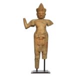A Khmer (Cambodian) sandstone figure of Vishnu, the deity clad in a short incised sampot, with a