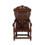 A carved oak armchair in 17th century style, bearing the inscription and date 'comfort ye one