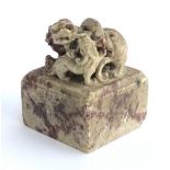 A Chinese carved soapstone seal surmounted by a foo dog and puppy, red ink remnants to seal, 5.5cm