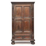 An 18th century oak cupboard, moulded pediment over a single panelled door and panelled sides,