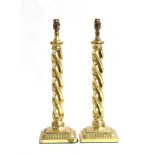 A pair of gilt metal table lamps, spiralled columns on square stepped bases, 49cm high to base of