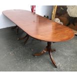 A mahogany D-end dining table in Regency style, having three pedestals, each with swept legs and