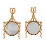 A pair of oversize modern giltwood wall mirrors, with bevelled circular plates within ribbon and