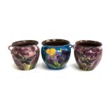 A pair of large purple ground Lemon and Crute Torquay pottery tri-handled jardinieres, painted with