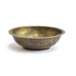 An Islamic brass divination bowl, the interior decorated with Arabic script, 18.5cm diameter