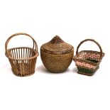 A Native American woven lidded basket, 35cm high; together with two further wicker baskets (3)