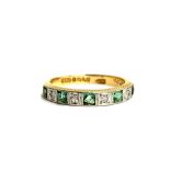 An 18ct gold and platinum ring set with diamonds and princess cut emeralds (one chipped), hallmarked