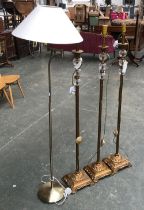 A trio of gilt metal and glass standard lamps; and one other (4)