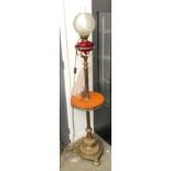 A standing oil lamp with ruby glass reservoir, with chimney and shade, converted for electrical use,