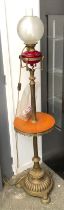 A standing oil lamp with ruby glass reservoir, with chimney and shade, converted for electrical use,