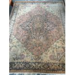 A large faded rug, central quatrefoil lozenge, 335x260cm
