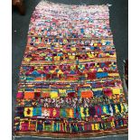 A flat woven brightly coloured rug, 260x163cm