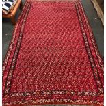 A large red ground Kilim rug with dense pink floral design, 395x221cm