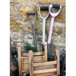 A pair of small wooden children's garden chairs together with a garden fork and 2 spades