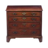 A George III mahogany chest of four graduating drawers, flanked by reeded canted corners, on bracket