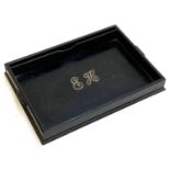 An early 20th century ebony desk tray, with single divider, and white metal monogrammed initials '
