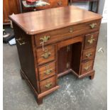 A George III mahogany kneehole dressing table, moulded top opening to a green baize writing