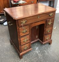 A George III mahogany kneehole dressing table, moulded top opening to a green baize writing