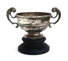 A large silver twin handled trophy cup on turned ebonised base, by Walker & Hall, Sheffield 1904,
