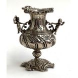 A Victorian silver vase with figural cherub handles and foliate pierced base, bears London import