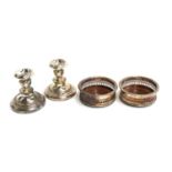 A pair of pierced silver plated wine coasters, 13cmD; together with a pair of plated candlesticks