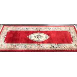 A red ground Chinese wool runner rug, 250x92cm