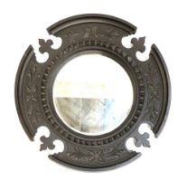 A small carved oak circular mirror, the bevelled plate within a carved border with trefoil detail,