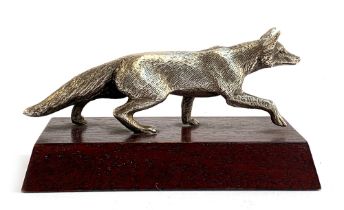 A white metal figure of a prowling fox, approx. 15cm long