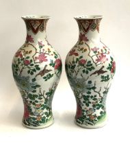 A pair of large Chinese famille rose baluster vases decorated with scenes of birds amongst