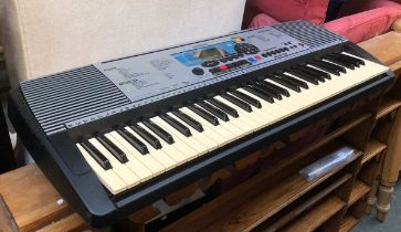 A Yamaha PSR-225GM electric keyboard with stand