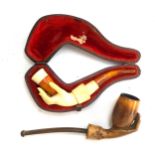 Two meerschaum pipes in the form of a hand, one in a fitted case, 10.5cmL and 12.5cmL