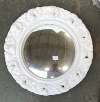 A circular convex mirror with carved white painted frame, 38cmD