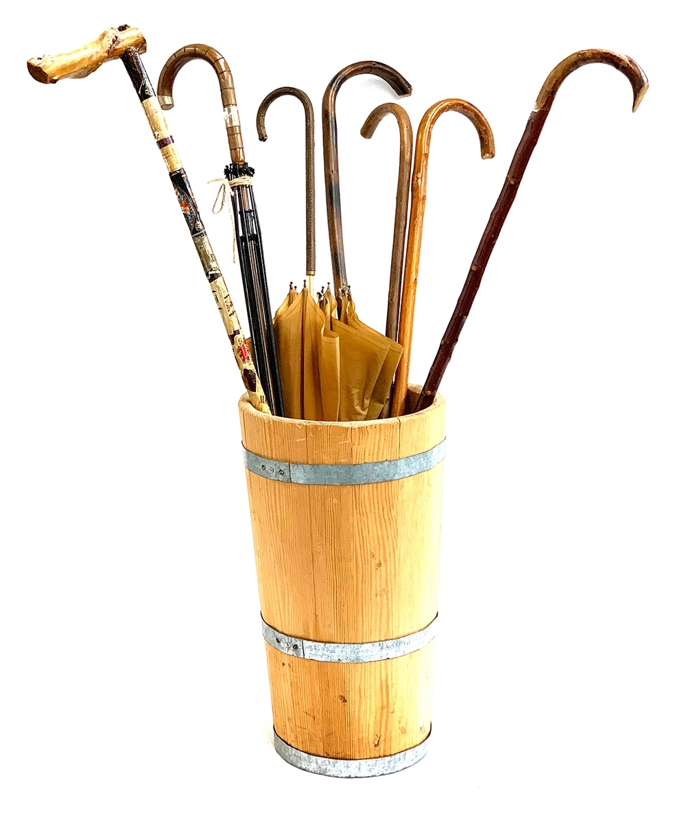 A coopered stick stand, containing several walking sticks, an umbrella with silver collar, etc