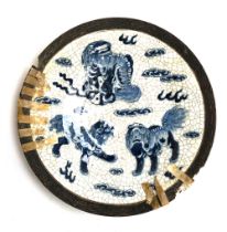 A Chinese crackle glaze plate depicting three foo dogs amongst rui clouds, character marks to