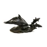 A cold cast bronze resin figure group of two dolphins chasing salmon, 51cmL