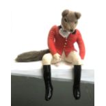 A stuffed anthropomorphic fox dressed as a huntsman