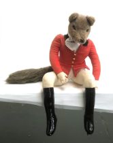 A stuffed anthropomorphic fox dressed as a huntsman