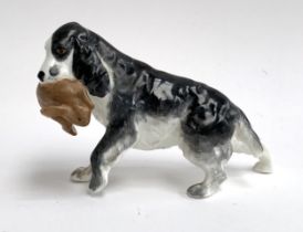 A Royal Worcester porcelain figure of a spaniel holding a rabbit, model number 3310, 9cmH