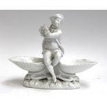 A blanc de chine figural salt, in the form of a piper, with blue underglaze Meissen crossed sword