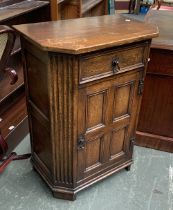 An 18th century style oak cabinet with canted corners, with single drawer over a panelled cupboard