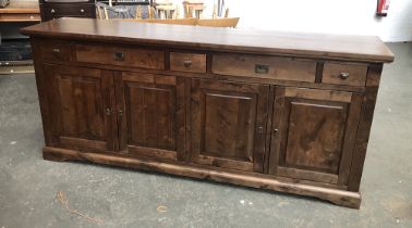 A large substantial stained hardwood sideboard, having five drawers above four locking cupboard