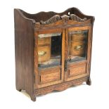 A 19th century oak smokers cabinet, glazed doors with bevelled glass, opening to a fitted interior