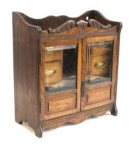 A 19th century oak smokers cabinet, glazed doors with bevelled glass, opening to a fitted interior