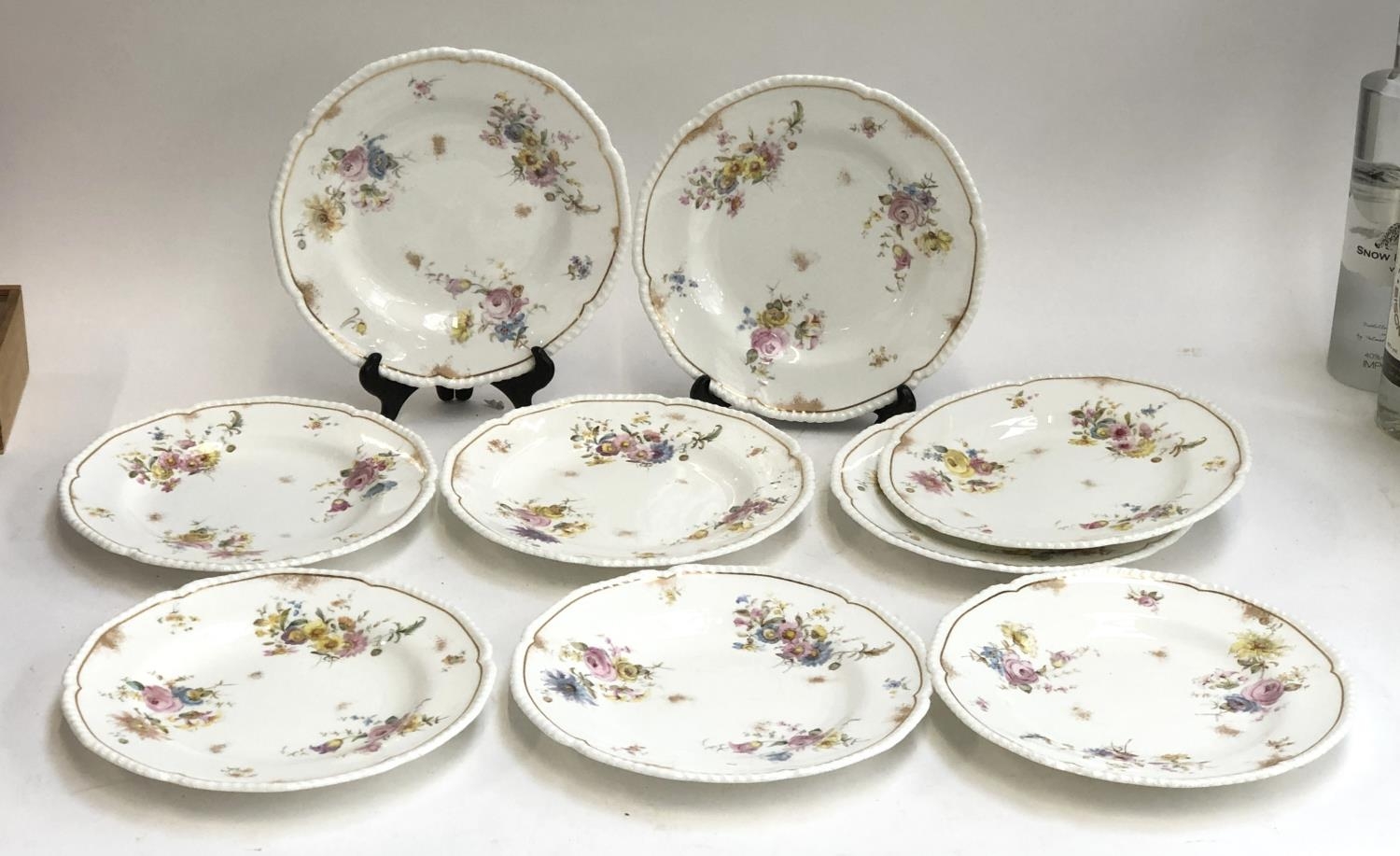A set of nine Royal Crown Derby dinner plates, hand painted floral spray design heightened in