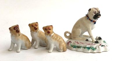 A Staffordshire pug figurine (af, leg missing), 7cm high; together with a trio of pug figurines